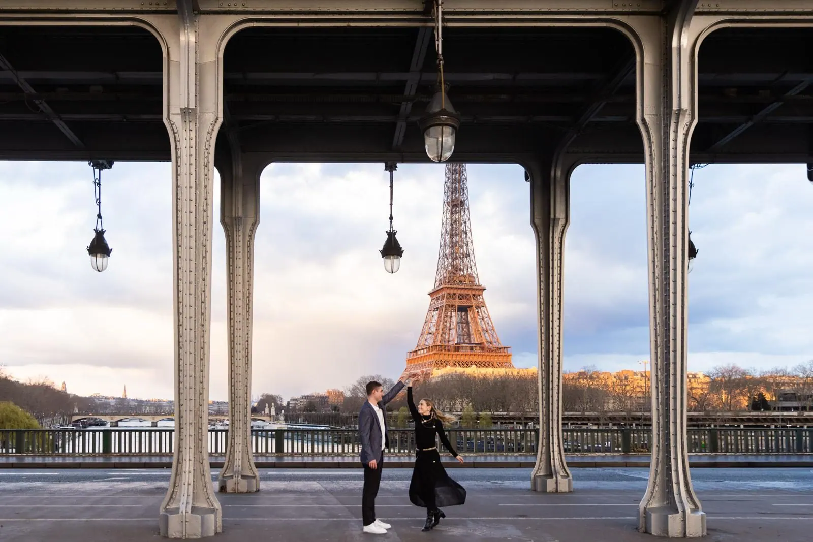 Couple dancing beneath the Pont de Bir-Hakeim with the Eiffel Tower behind them in Paris